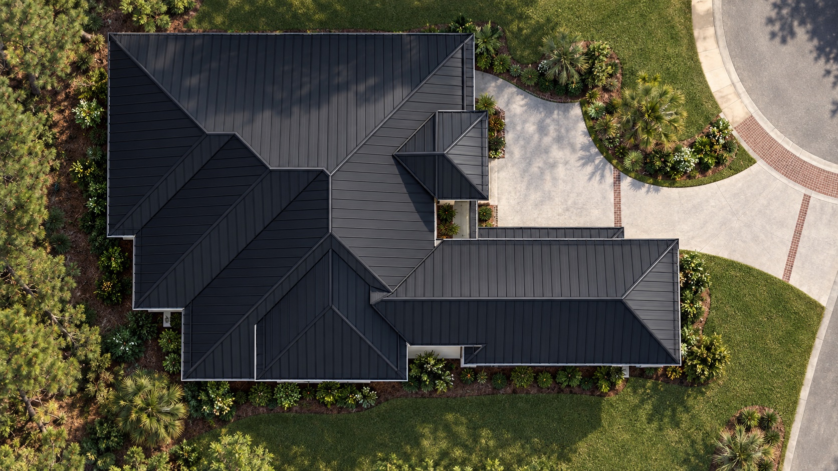 Overhead view of the residence — black standing-seam roof, drive court and the quiet cul-de-sac at the edge of the woods